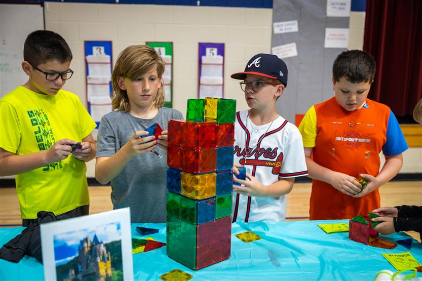 Four boys use Magna-Tiles